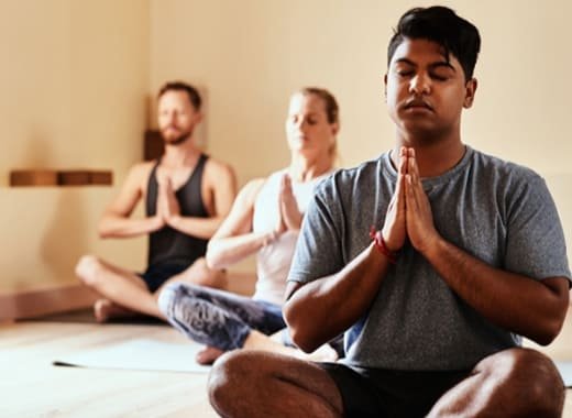 A group of individuals practicing meditation techniques in class, focusing on mindfulness and relaxation at a wellness center.