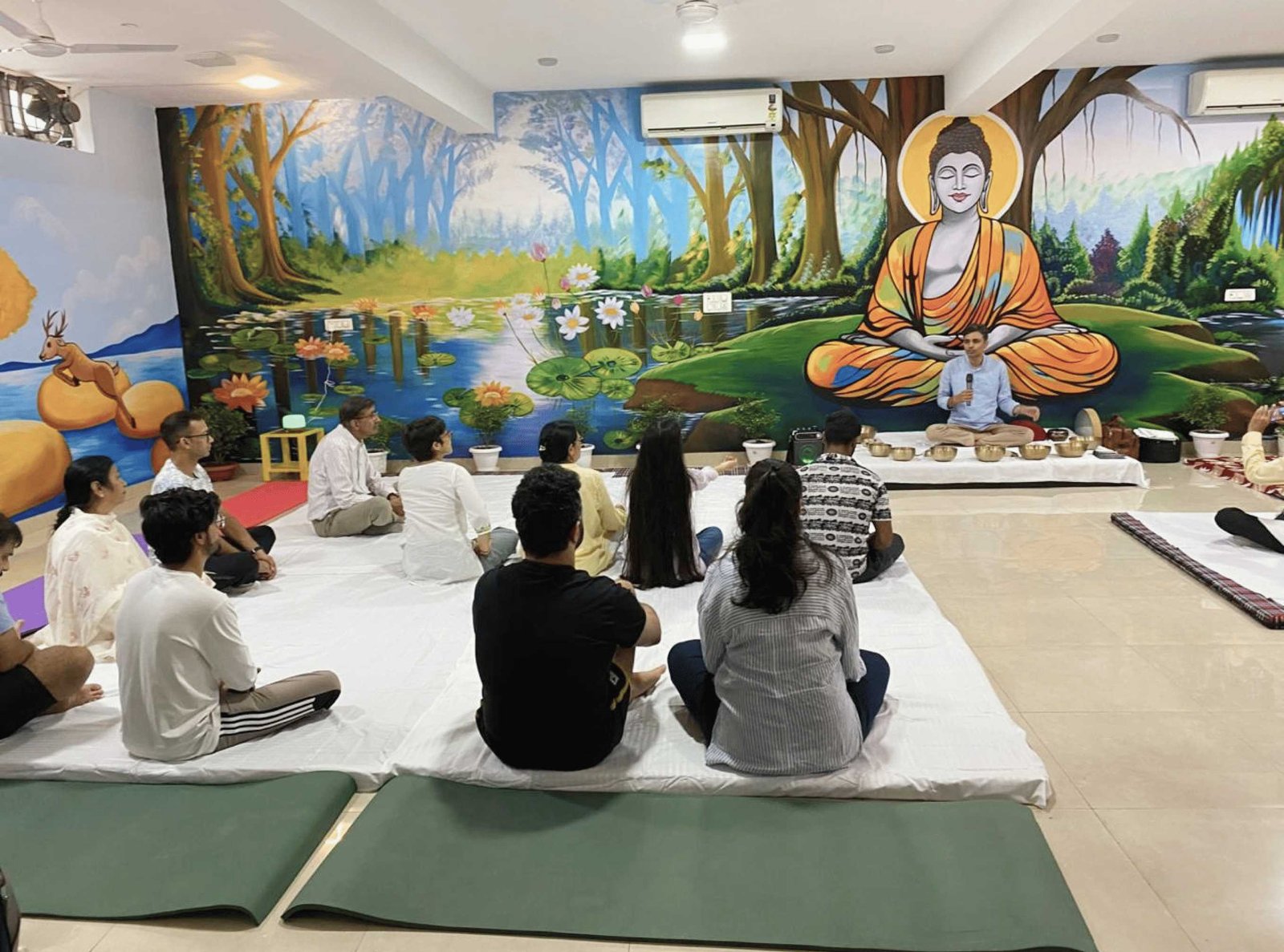 A guided meditation session in a serene indoor setting with a Buddha mural